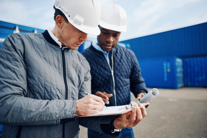 two-engineers-standing-in-a-container-yard-discuss-64BCESF telecommunication logistic services near me